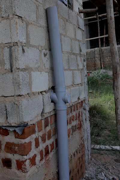 PVC downpipe on block wall